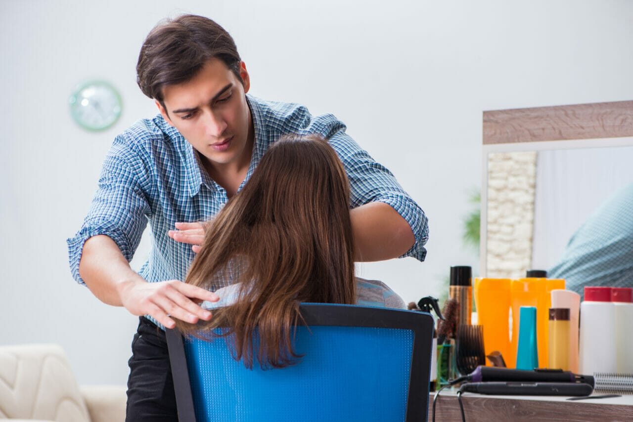 femme profitant d'un soin et du lissage de ses cheveux par un coiffeur professionnel